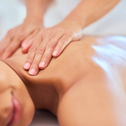 Luxury, wellness and zen spa massage on a young woman back, relaxing and stress free at a resort or center. Female enjoying healing treatment by a masseuse, pamper while massaging for muscle relief